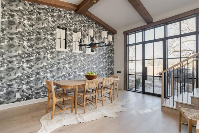 dining room with plenty of natural light, hardwood / wood-style floors, and lofted ceiling with beams