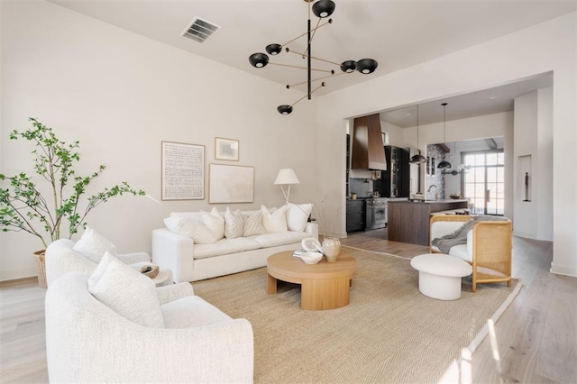 living room with a notable chandelier and light wood-type flooring