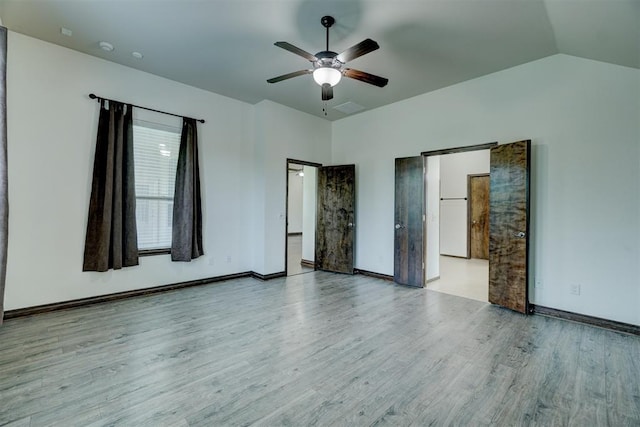 unfurnished bedroom with light hardwood / wood-style floors, vaulted ceiling, and ceiling fan