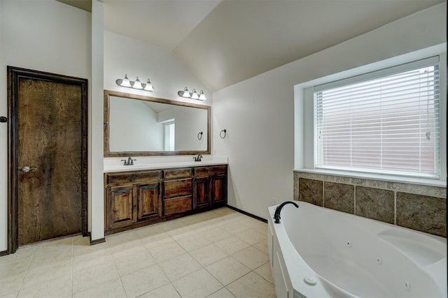 bathroom featuring tile patterned floors, a bathtub, lofted ceiling, and vanity