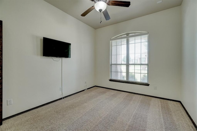 carpeted spare room with ceiling fan