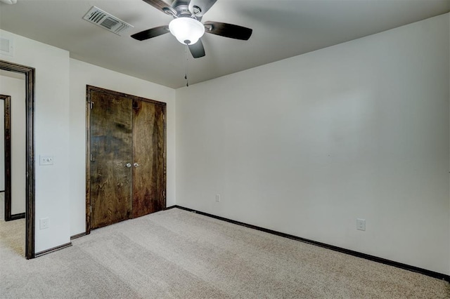 unfurnished bedroom featuring ceiling fan, a closet, and light carpet