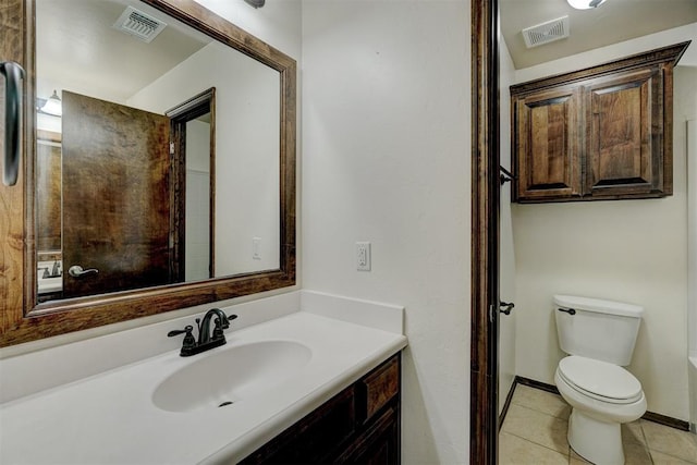 bathroom with tile patterned flooring, vanity, and toilet