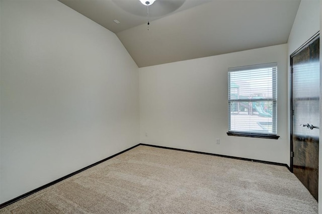 carpeted empty room with ceiling fan and lofted ceiling