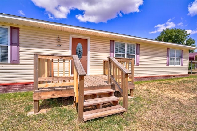 entrance to property with a lawn and a deck