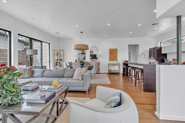 living room with light wood-type flooring and sink