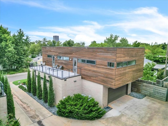 view of side of home featuring a balcony and a garage