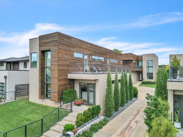 view of side of home with a lawn and a balcony