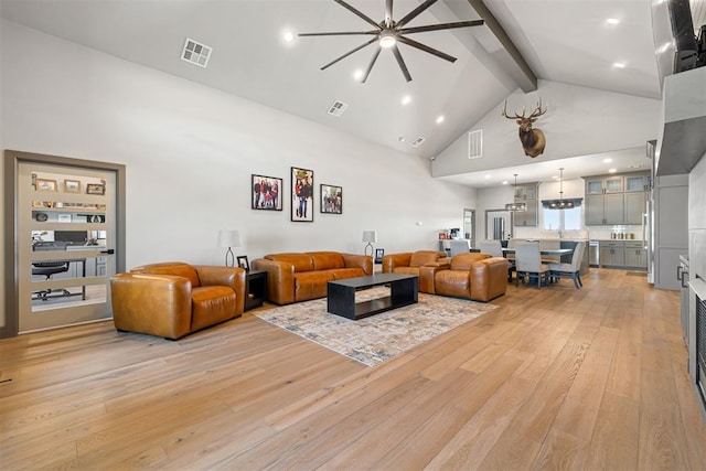 living room featuring ceiling fan with notable chandelier, beam ceiling, high vaulted ceiling, and light hardwood / wood-style flooring