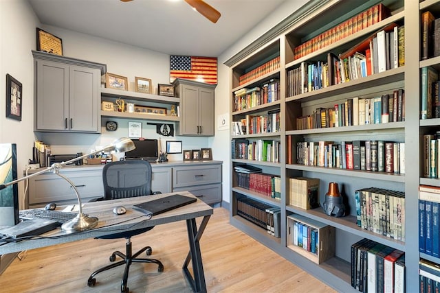 office space with built in desk and light hardwood / wood-style floors