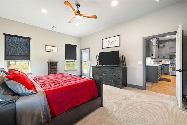 carpeted bedroom with multiple windows and ceiling fan