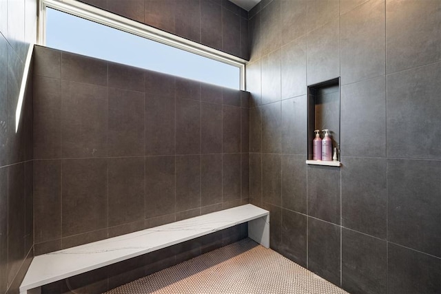 bathroom featuring tiled shower and tile walls