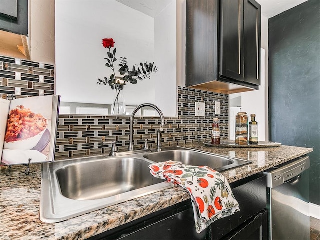 kitchen featuring stainless steel dishwasher, light stone counters, sink, and backsplash