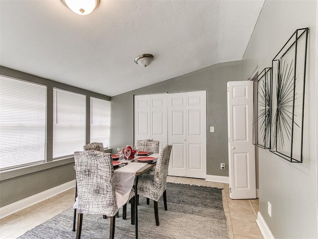 tiled dining area with vaulted ceiling