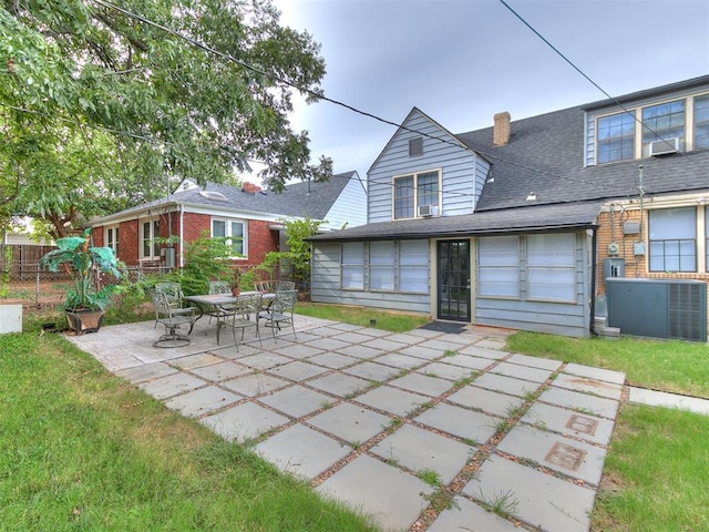 back of property featuring cooling unit, a patio area, and a lawn