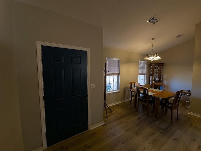 dining space featuring a chandelier, hardwood / wood-style floors, and lofted ceiling