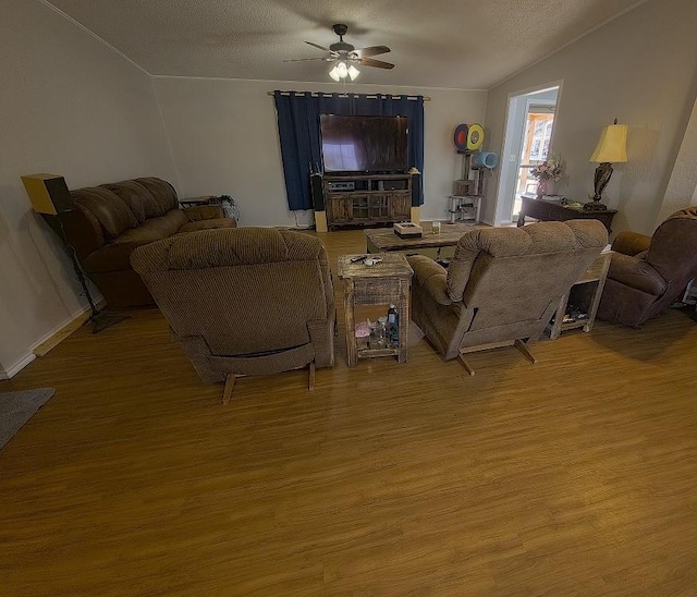 living room featuring ceiling fan, wood-type flooring, a textured ceiling, and vaulted ceiling