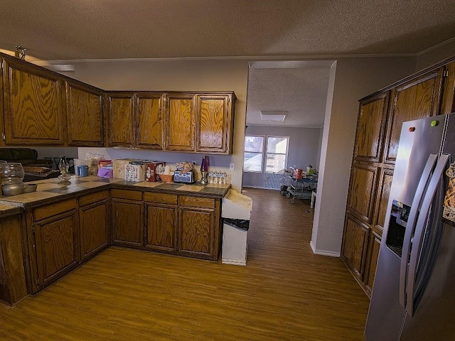 kitchen with stainless steel fridge, a textured ceiling, and light hardwood / wood-style flooring