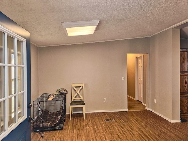 interior space featuring crown molding, a textured ceiling, and hardwood / wood-style flooring