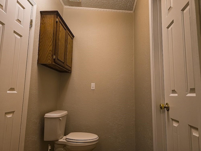 bathroom featuring crown molding, toilet, and a textured ceiling