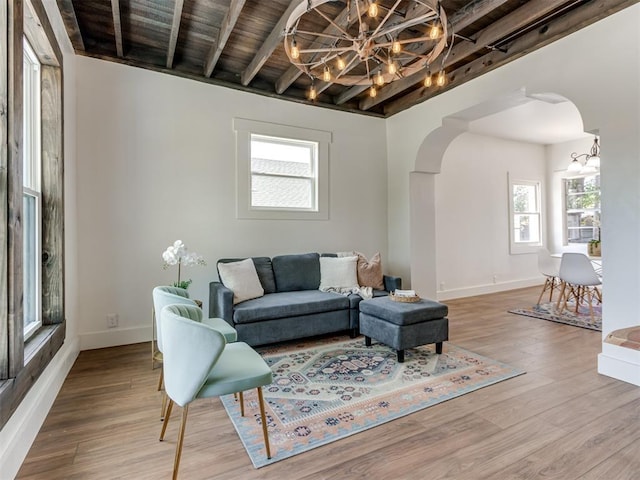 living room with beamed ceiling, hardwood / wood-style floors, wooden ceiling, and a chandelier