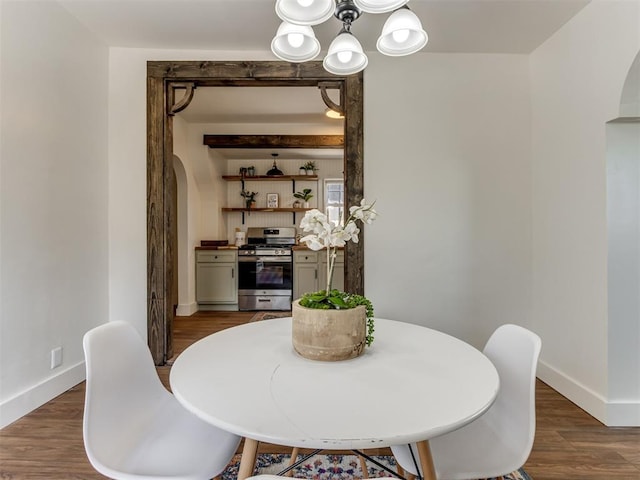 dining room with dark wood-type flooring and a notable chandelier