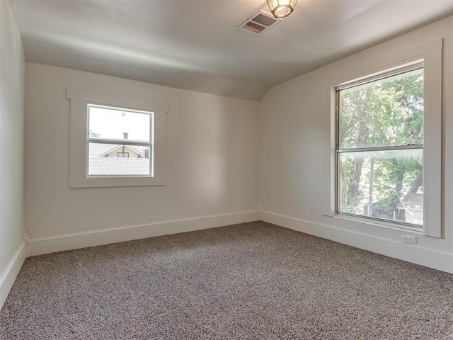 carpeted spare room with vaulted ceiling