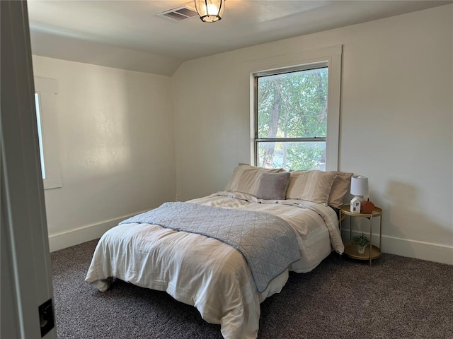 bedroom featuring dark colored carpet and vaulted ceiling