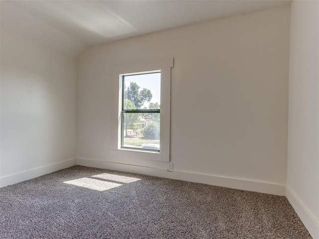 empty room featuring lofted ceiling and carpet