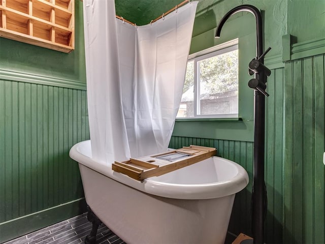 bathroom with a tub to relax in and hardwood / wood-style floors