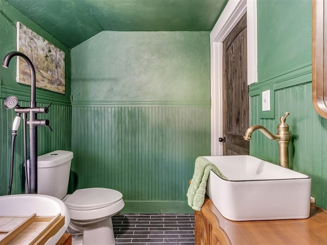 bathroom featuring hardwood / wood-style flooring, vaulted ceiling, and toilet