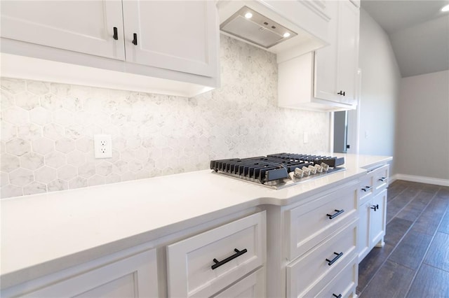 kitchen with dark wood-style flooring, stainless steel gas cooktop, light countertops, white cabinets, and premium range hood