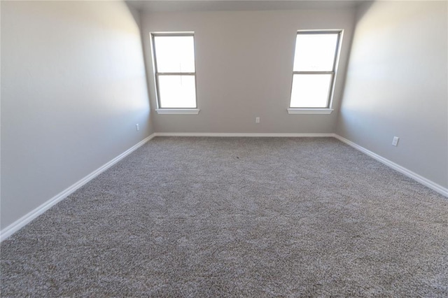 empty room featuring carpet floors and baseboards