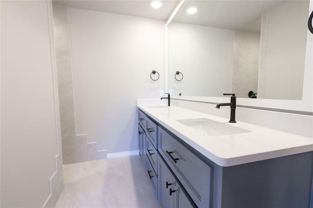 bathroom with recessed lighting, a sink, baseboards, and double vanity