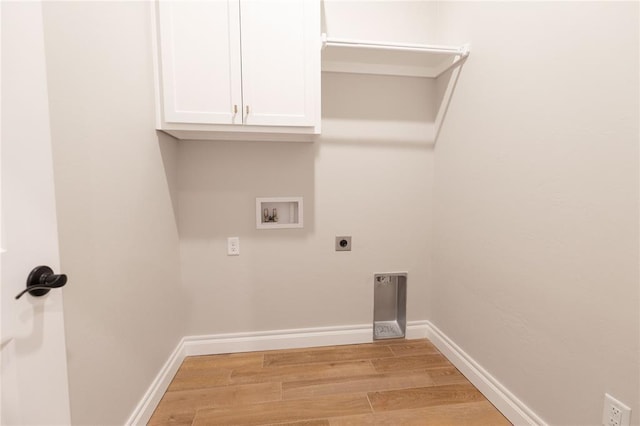 clothes washing area with hookup for a washing machine, cabinet space, light wood-style flooring, hookup for an electric dryer, and baseboards