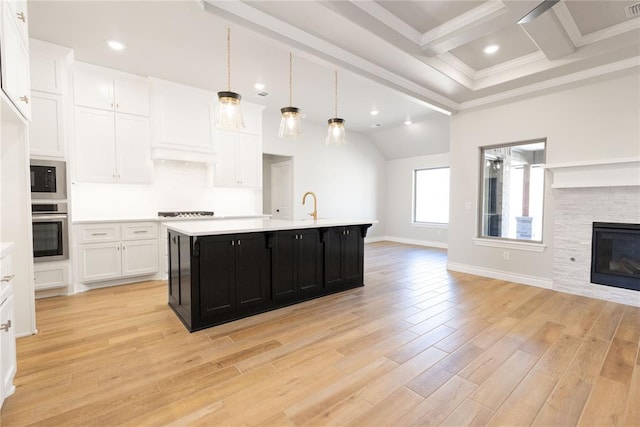 kitchen featuring dark cabinets, stainless steel appliances, white cabinetry, open floor plan, and light countertops