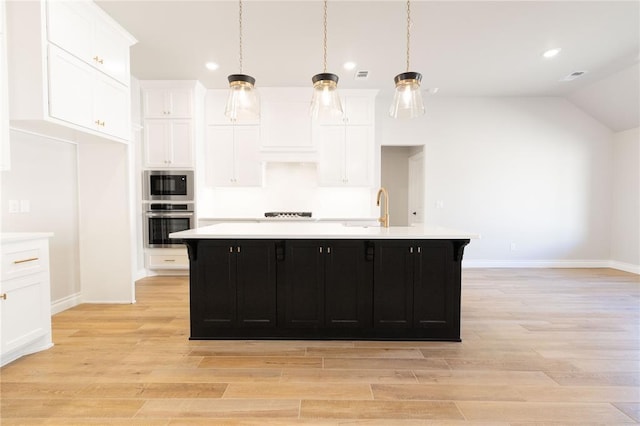 kitchen featuring stainless steel appliances, light countertops, white cabinets, and dark cabinetry