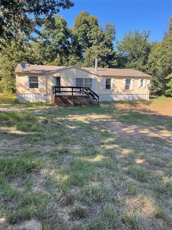 view of front of property featuring a deck and a front lawn