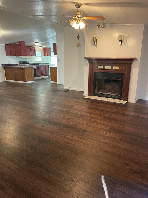 unfurnished living room featuring a textured ceiling, ceiling fan, dark wood-type flooring, and vaulted ceiling