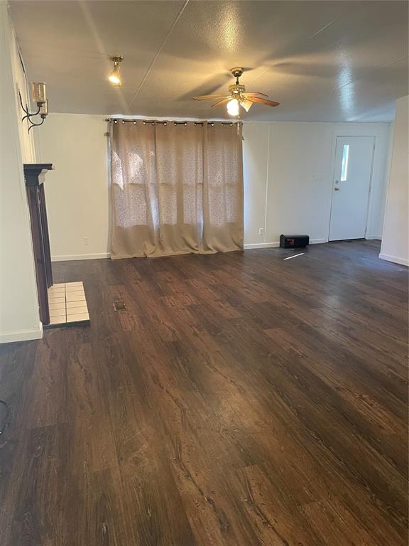 unfurnished living room with ceiling fan and dark hardwood / wood-style flooring