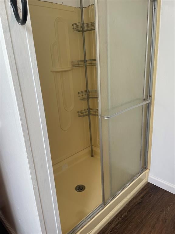 bathroom featuring a shower with shower door and hardwood / wood-style flooring