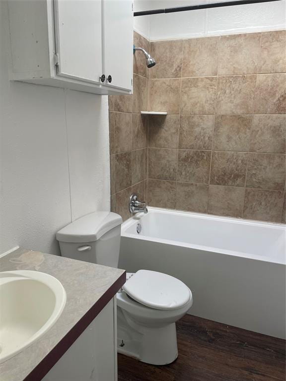 full bathroom with vanity, wood-type flooring, tiled shower / bath combo, and toilet