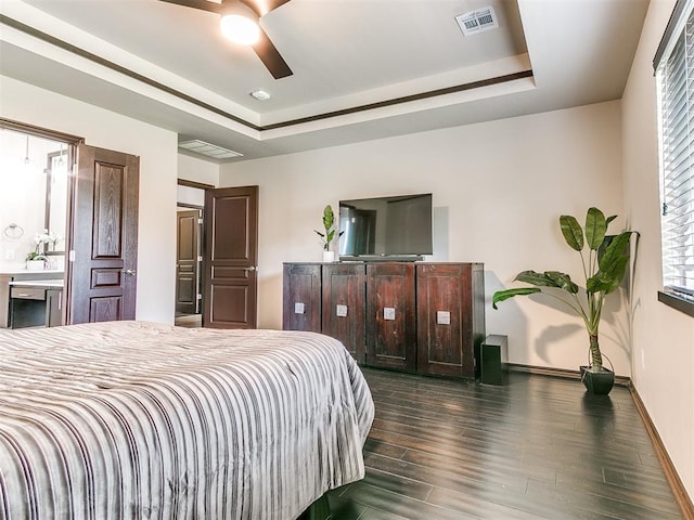 bedroom featuring a raised ceiling, ceiling fan, and dark hardwood / wood-style flooring