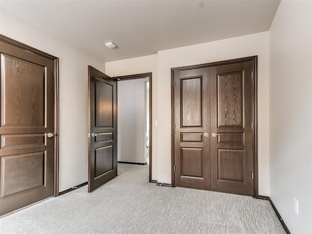 unfurnished bedroom featuring light carpet and a closet