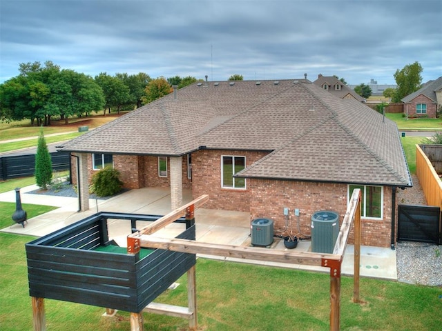 rear view of property featuring a lawn, cooling unit, and a patio