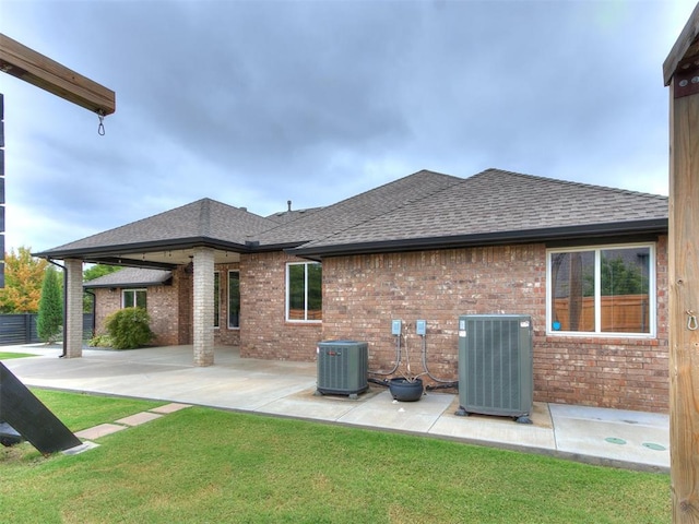 rear view of property featuring a yard and cooling unit