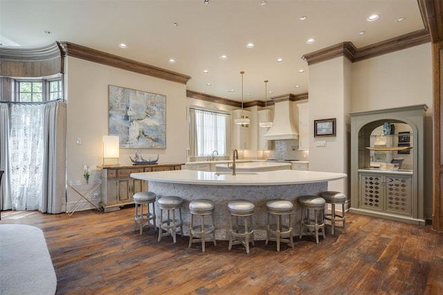 kitchen with pendant lighting, a spacious island, custom range hood, and a wealth of natural light