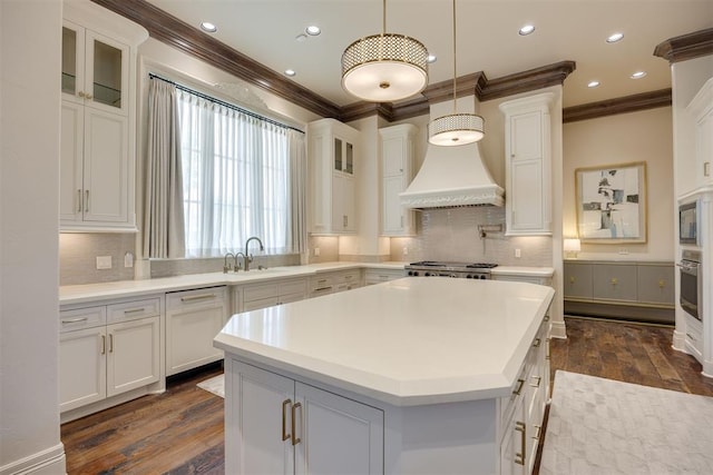 kitchen featuring dark hardwood / wood-style flooring, decorative light fixtures, a kitchen island, and white cabinetry