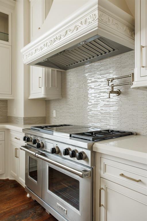 kitchen featuring range with two ovens, premium range hood, and tasteful backsplash