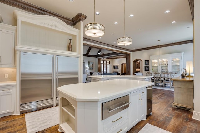 kitchen featuring white cabinets, hanging light fixtures, and stainless steel built in refrigerator